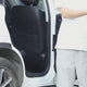 Black seat-back organiser strapped over a car's front seat: the buckles done up, pens and a water bottle stowed, tissues pulled through the slot, then the Tan, CP Camo, Black Camo and Army Green versions fitted.