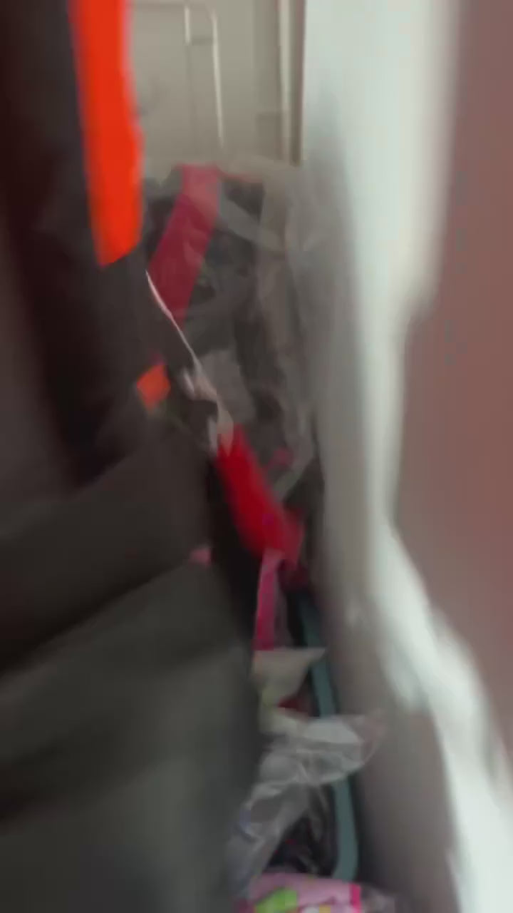 Close-ups of the orange buoyancy vest with black side panels: the back, then the front straps and buckles clipped and adjusted.