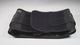 Hands showing the black lumbar support belt: the wide back panel with its stays, the double-pull elastic straps being stretched and the moulded back pad fitted into the panel.
