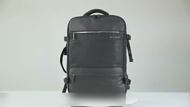 Black expandable laptop backpack on a table: the padded back and straps, then the expansion zip opened out and clothes packed into the main compartment.