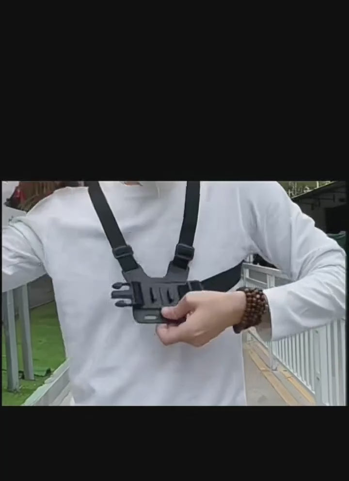 Chest strap mount buckled on over a white shirt, a phone clipped into the holder and angled forward to film.