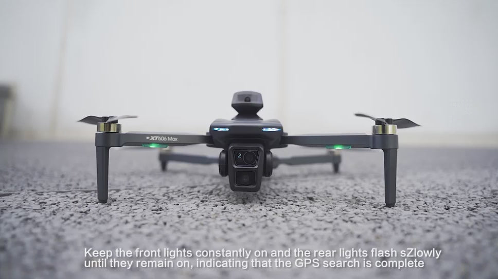 XT606 drone on the ground, the screen remote's buttons pressed, then the drone lifting off and hovering beside a building.