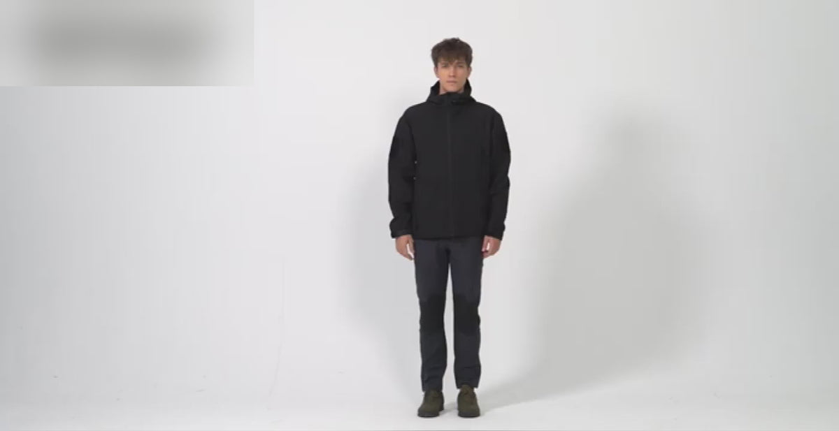 Man in the black TACVASEN fleece-lined softshell: the full zip, the arm pocket, the inside pocket, water beading off the front, and a walk-round.