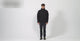 Man in the black TACVASEN fleece-lined softshell: the full zip, the arm pocket, the inside pocket, water beading off the front, and a walk-round.