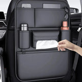 A hand pulling a tissue from the centre pouch of the black PU seat back organiser