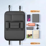 Black PU seat back organiser laid flat beside a phone, tablet, bottles, sunglasses and books, with its top and bottom straps