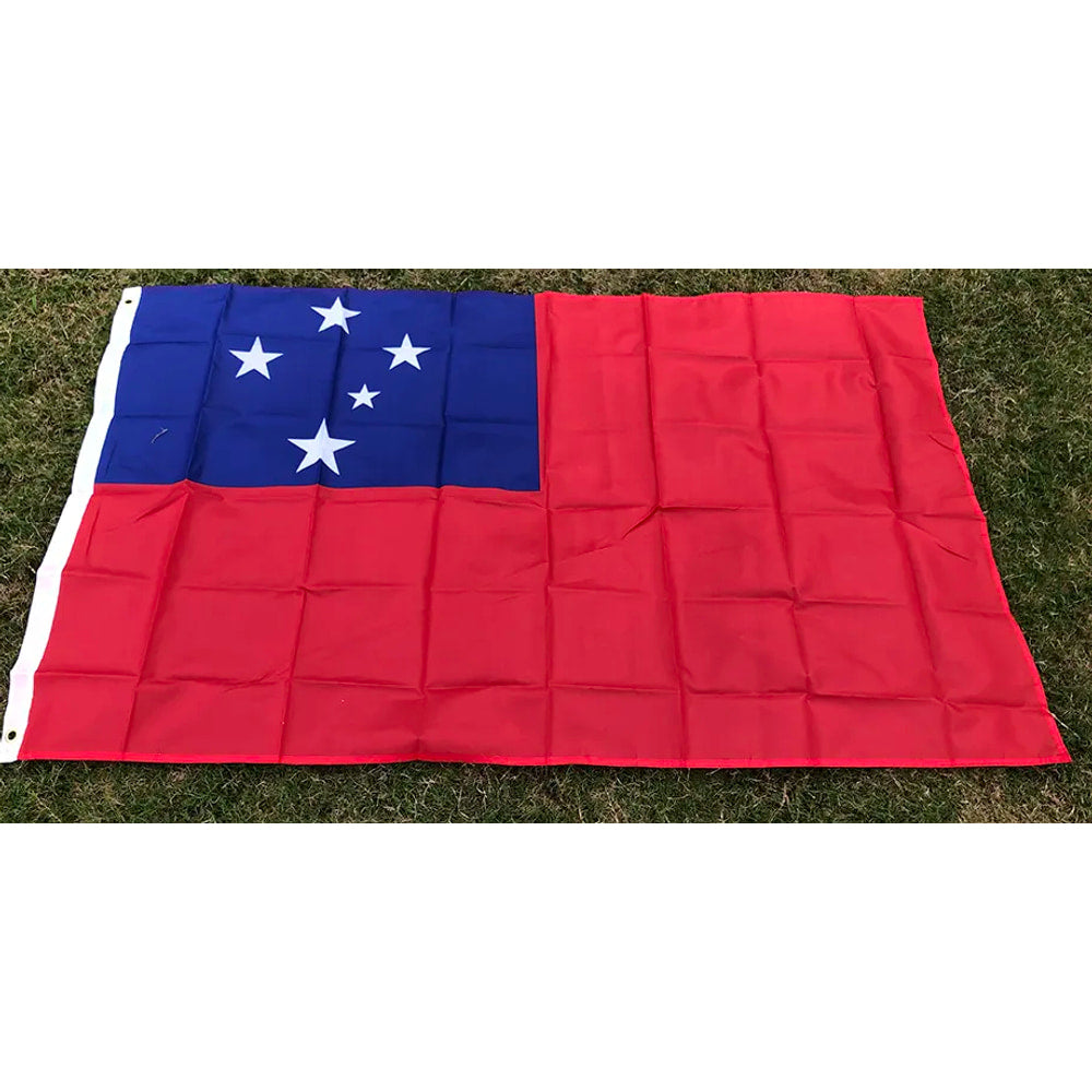 Samoan flag in printed polyester laid flat on grass: red with blue canton and five white stars, header strip at left