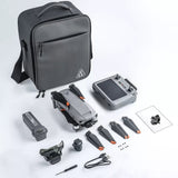 Photo of the SG909MAX kit laid out: carry bag, folded drone, touch-screen remote, battery, obstacle-avoidance module, spare propellers, screws, USB lead, screwdriver and manual
