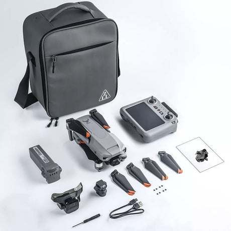 Photo of the SG909MAX kit laid out: carry bag, folded drone, touch-screen remote, battery, obstacle-avoidance module, spare propellers, screws, USB lead, screwdriver and manual