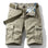 Khaki RELAX six-pocket cargo shorts laid flat, front view, fly open to show the printed inner waistband, with an olive webbing belt used for styling