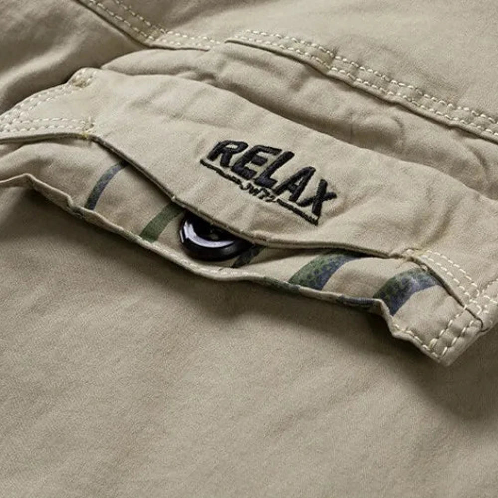 Close-up of the RELAX embroidered cargo pocket flap and its dark button on the khaki shorts