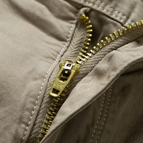 Close-up of the brass-toned metal zip fly with the pull stamped VEK on the khaki RELAX shorts