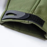 Close-up of a green jacket cuff with its black hook-and-loop adjuster tab and the lining inside the sleeve