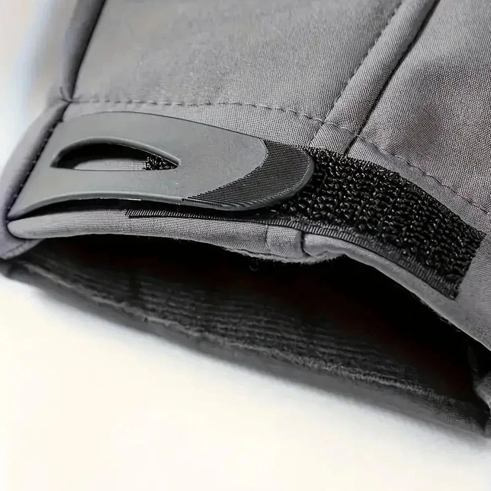 Close-up of a grey jacket cuff with its black hook-and-loop adjuster tab and the lining inside the sleeve