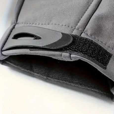 Close-up of a grey jacket cuff with its black hook-and-loop adjuster tab and the lining inside the sleeve