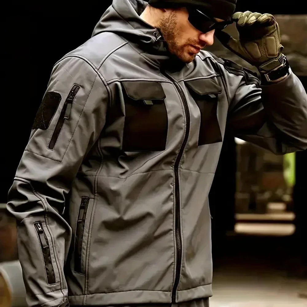 Man in the grey softshell jacket with black chest pockets; beanie, sunglasses, watch, gloves, trousers not included