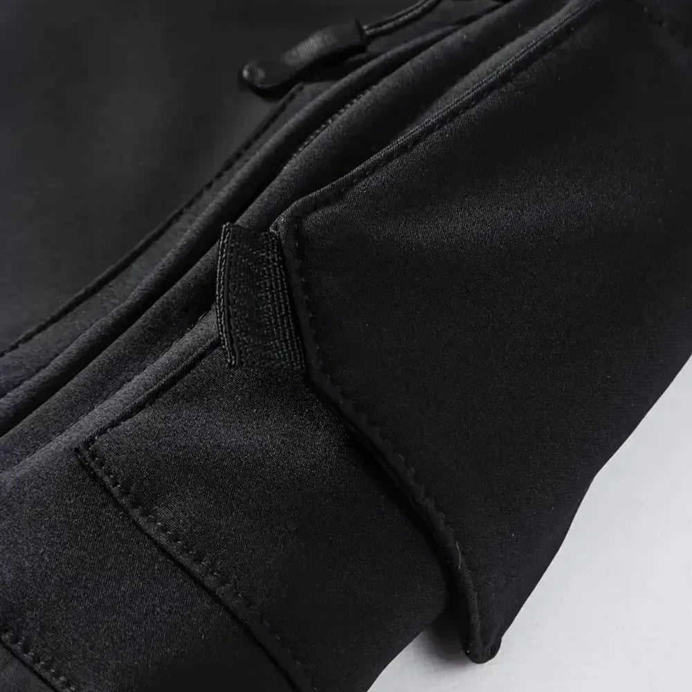 Close-up of a zipped pocket under a flap on the black jacket's sleeve