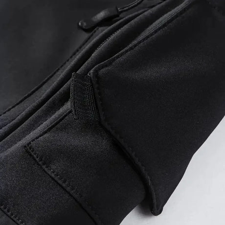 Close-up of a zipped pocket under a flap on the black jacket's sleeve