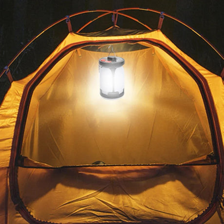 Tall lantern hanging from the roof of a tent at night