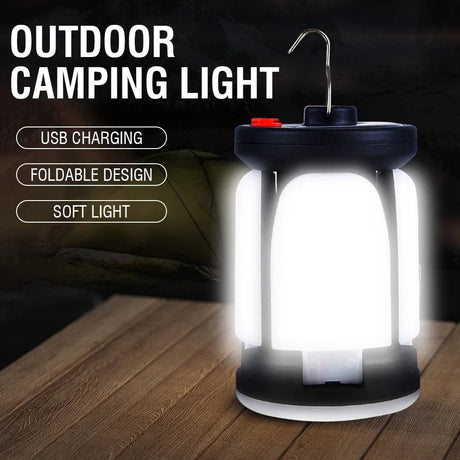 Tall camping lantern glowing on a timber table, with a wire hook on top