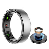 Silver Uhoofit R10 smart ring showing the sensors inside the band, beside a gold ring above its black charging dock