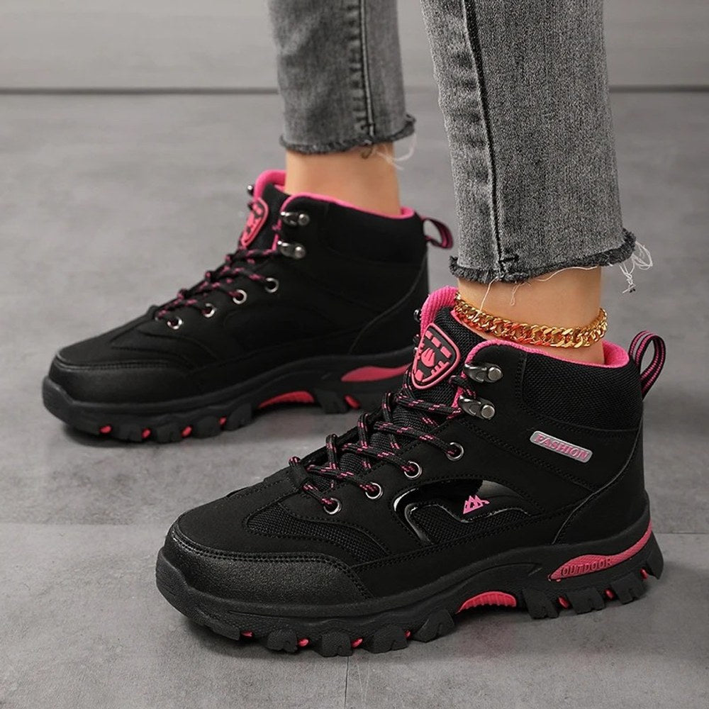 Black and rose red hiking boots worn, showing the lace-up front and rubber lug outsole