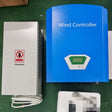 WW10 1 kW set: blue Wind Controller with LCD beside its tall white finned dump load box with a no-touching warning label and coiled cable, on a green workbench