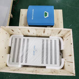 Blue WW50 wind controller and white finned dump load resistor box packed in a plywood shipping crate
