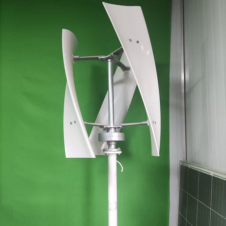 White three-blade X-series helical turbine on a white pole against a green wall indoors, showing the hub, arms and mounting flange - representative X-series photo.