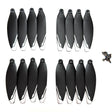 Sixteen black XT606 drone propellers with white tips and their mounting screws