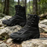 Pair of black high lace-up field boots with mesh panels and lace hooks at the top, standing on rocks in a forest