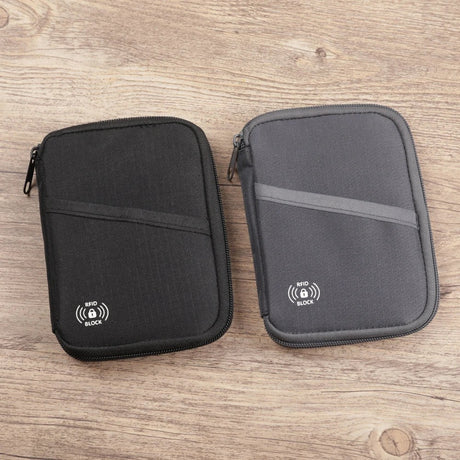 The black and grey pouches side by side on a wooden desk