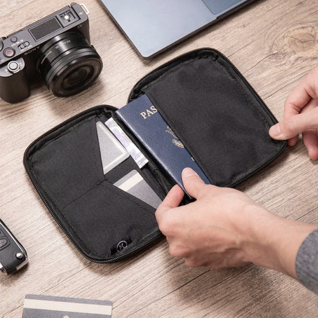 Hand sliding a passport into the open pouch next to the card pockets