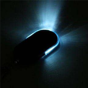 Blue key finder fob in darkness with its edge strip lit pale blue