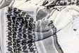 Close-up of white and black shemagh showing fringe and banded weave detail