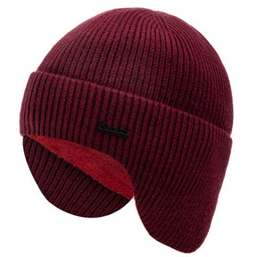 Red wool beanie from the side with the earflaps down, contrasting red fleece lining visible inside