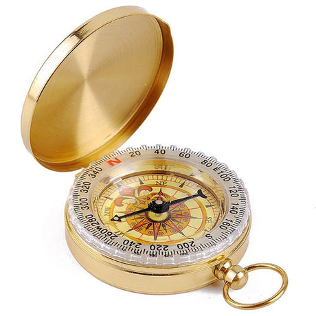 Brass-coloured lid compass open, showing a dial marked in degrees